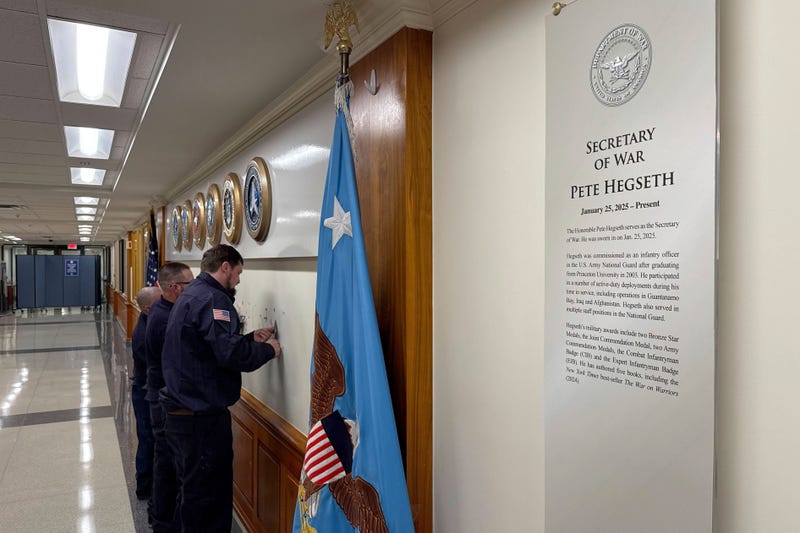 FILE - Workers remove sign lettering at the Pentagon after President Donald Trump signed an executive order aiming to rename the Department of Defense the Department of War in Washington, Sept. 5, 2025.