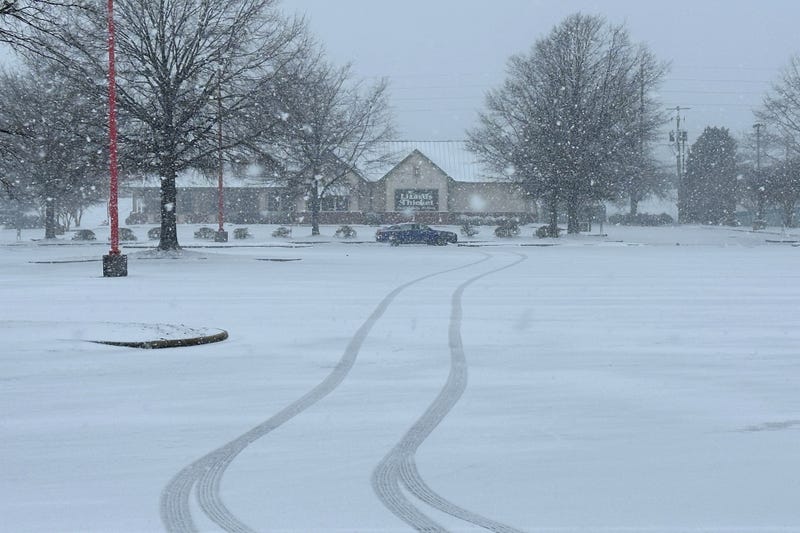 Snow falls outside a shopping center in Columbia, S.C., on Saturday, Jan. 31, 2026.