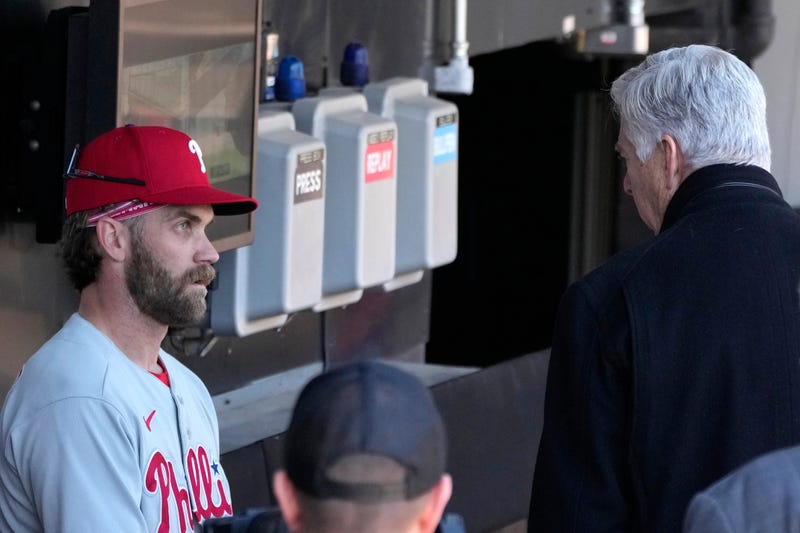 Philadelphia Phillies' Bryce Harper, left, listens to club President David Dombrowski, after Harper's workout before game one of a baseball double header against the Chicago White Sox, April 18, 2023, in Chicago. 