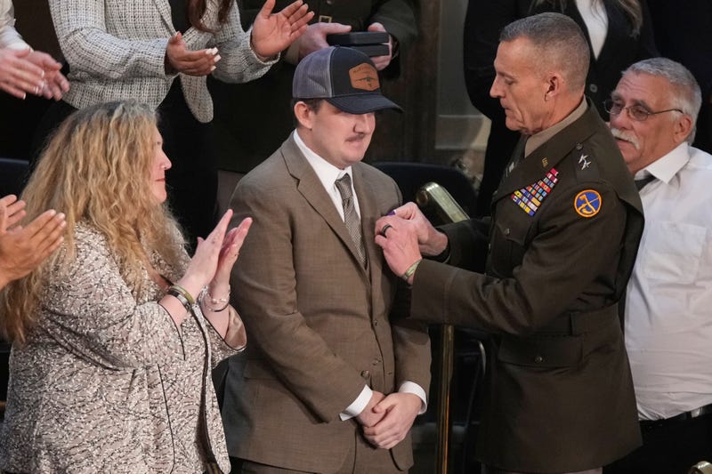 West Virginia National Guard Staff Sgt. Andrew Wolfe receive the Purple Heart as his mother, Melody, watches during President Donald Trump's State of the Union address to a joint session of Congress in the House chamber at the U.S. Capitol in Washington, Tuesday, Feb. 24, 2026.
