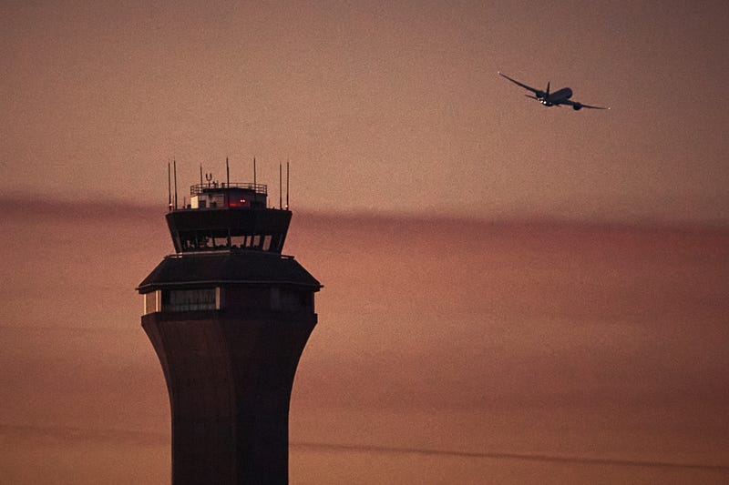 A plane flies by a control tower at Newark Liberty International Airport on Nov. 7, 2025, in Newark, N.J. 