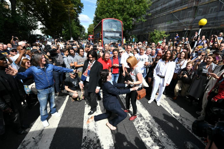 A Paul McCartney impersonator proposes to his girlfriend as a group of Beatles look-alikes recreate the iconic 'Abbey Road' photograph