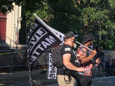 BLM Activists watch the work on the Lee Monument