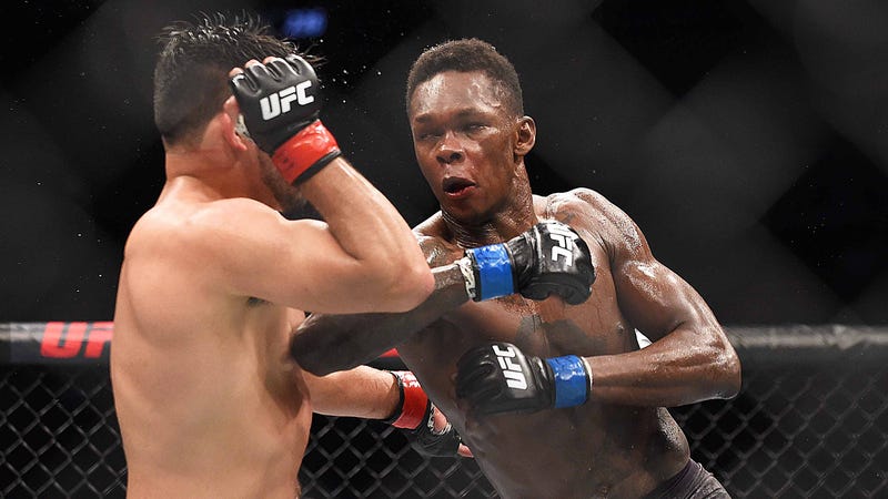 Israel Adesanya strikes Kelvin Gastelum during their interim middleweight title bout at UFC 236.