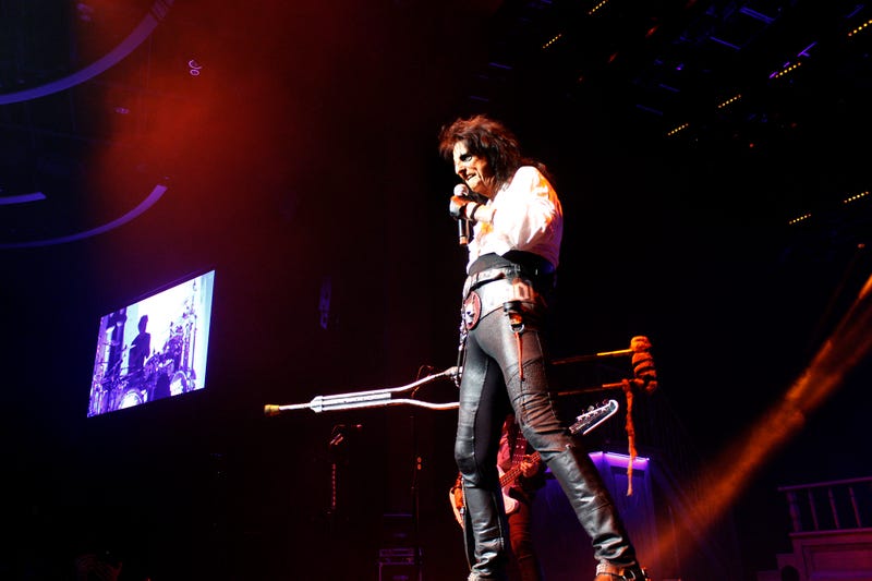 Alice Cooper carrying crutch singing to the crowd
