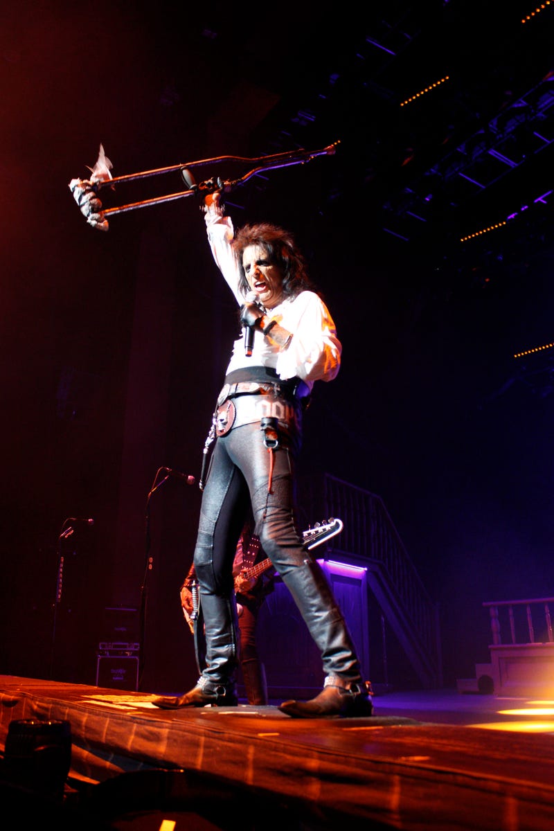 Alice Cooper raising crutch in the air