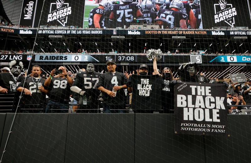 Las Vegas Raiders fans watch the team warm up before a game against the Miami Dolphins at Allegiant Stadium
