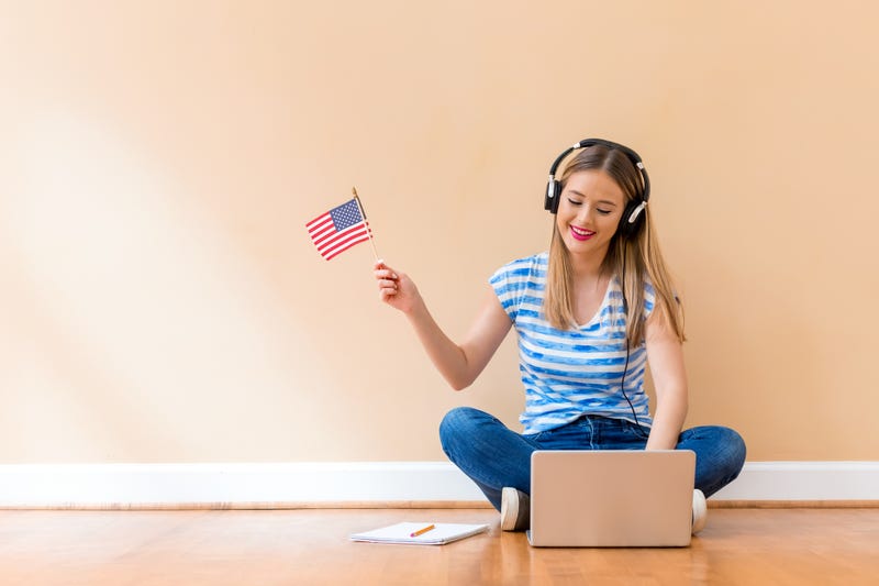 girl holding American flag with headphones on