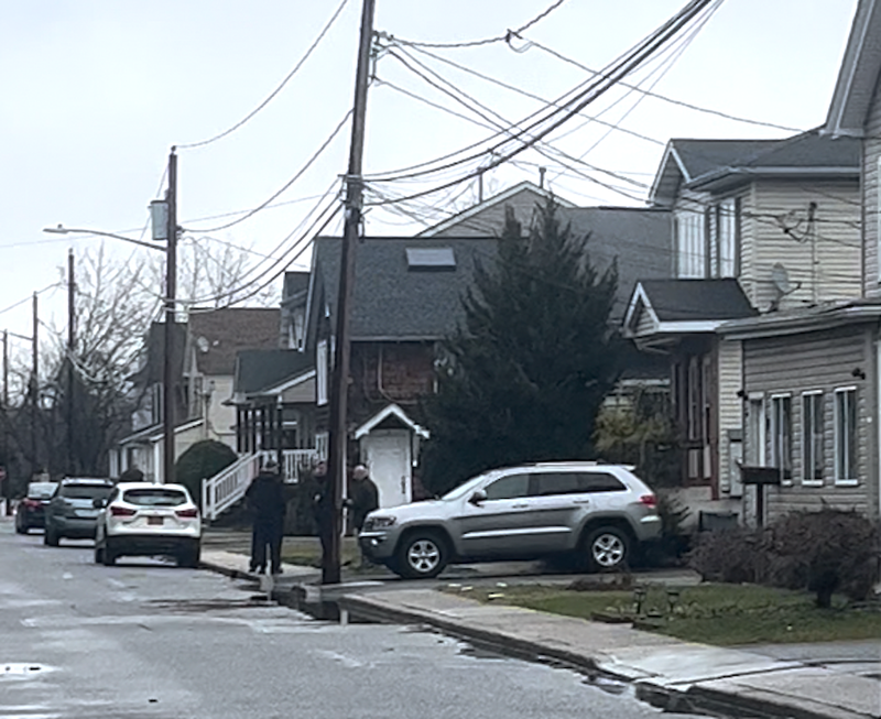 Homicide detectives are seen walking in and out of the home in Amityville on Tuesday morning