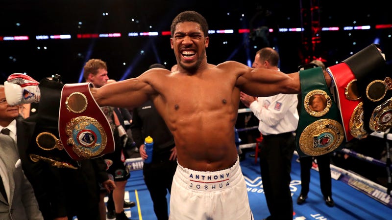 Heavyweight boxing champion Anthony Joshua poses in the ring with his belts
