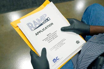 FILE - An applicant waits with paperwork at a rental assistance fair July 24, 2021, in Jackson, Miss. Housing officials in multiple states are reporting few fraudulent applications in their rental assistance programs. The federal government has poured billions of dollars into states during the pandemic. For unemployment benefits, states saw massive amounts of fraud as they rushed to get the money approved quickly.
