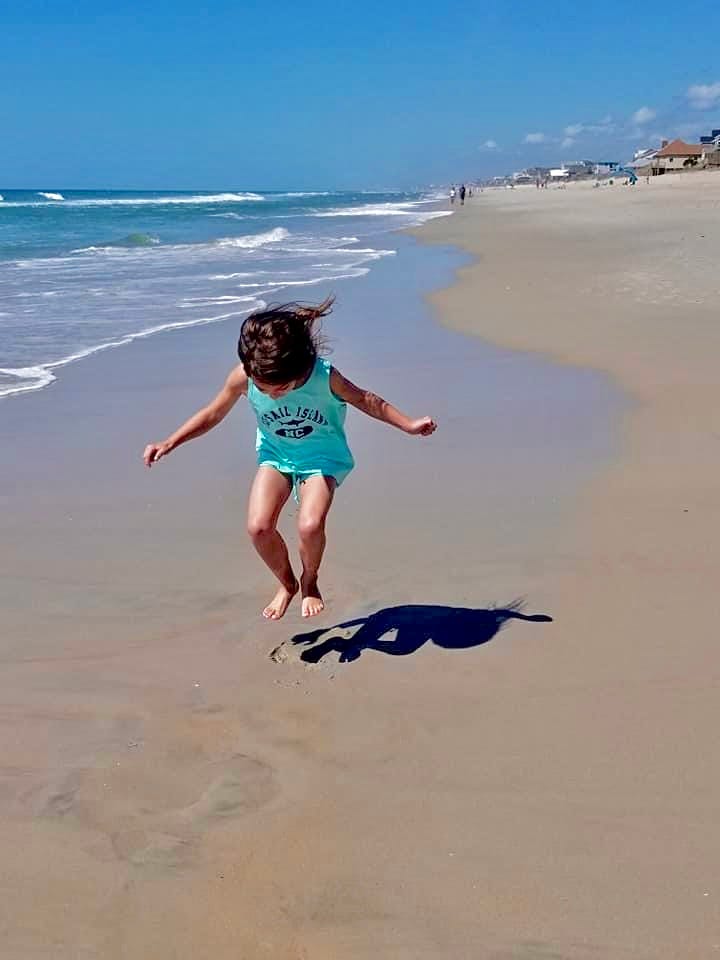 Averie jumping on the beach