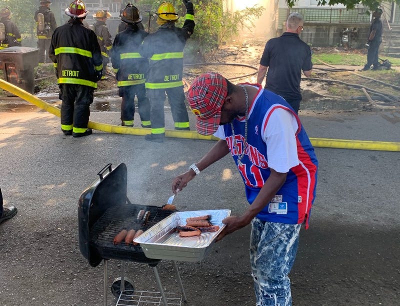 Detroiter grilling hot dogs near house fire