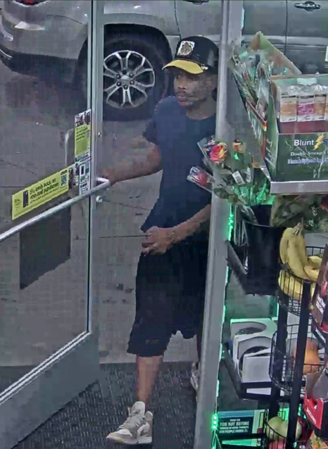 Photo of suspect in Detroit breaking and entering. Black male wearing a black or blue ball cap with a yellow brim, blue t-shirt and dark-colored shorts with white and gray Nike tennis shoes.
