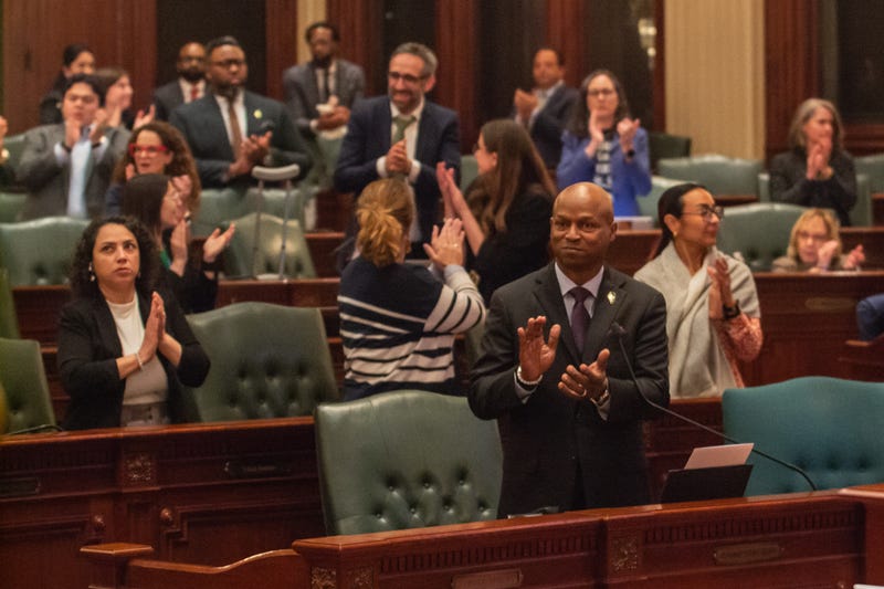 House Speaker Emanuel “Chris” Welch and members of his Democratic caucus applaud members of their staff early Sunday morning after the chamber approved the $55.2 billion budget bill.