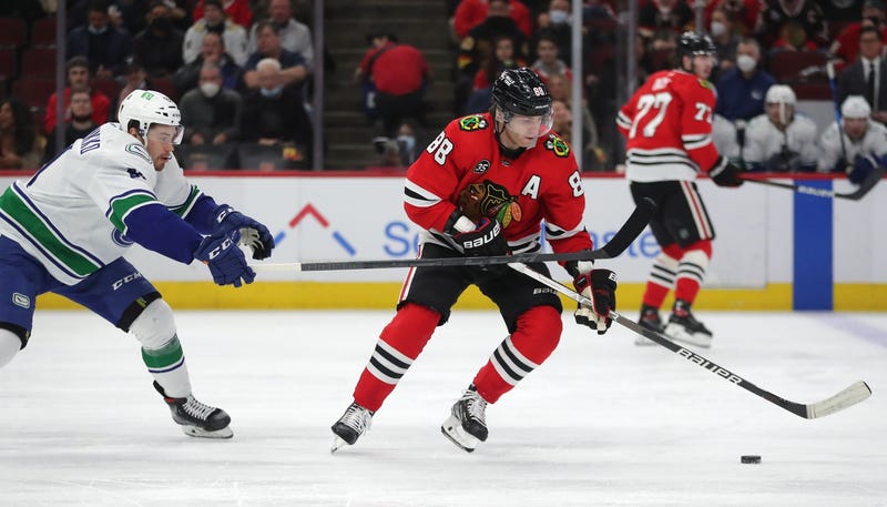 Blackhawks right wing Patrick Kane (88) is forechecked by Canucks left wing Juho Lammikko (91).