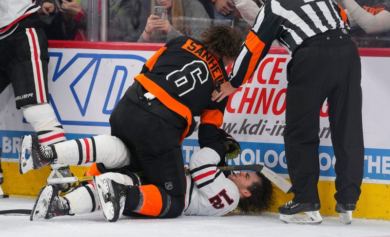 Flyers defenseman Travis Sanheim (6) fights Blackhawks left wing Alex DeBrincat (12).