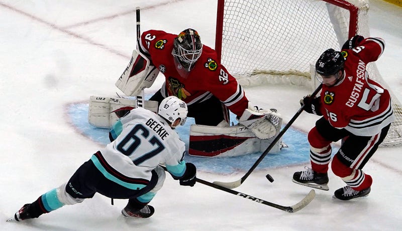 Kraken center Morgan Geekie (67) shoots the puck on Blackhawks goaltender Kevin Lankinen (32).