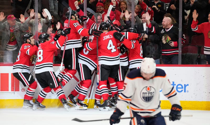 The Blackhawks celebrate after winger Alex DeBrincat scored a game-winning goal against the Oilers in overtime.