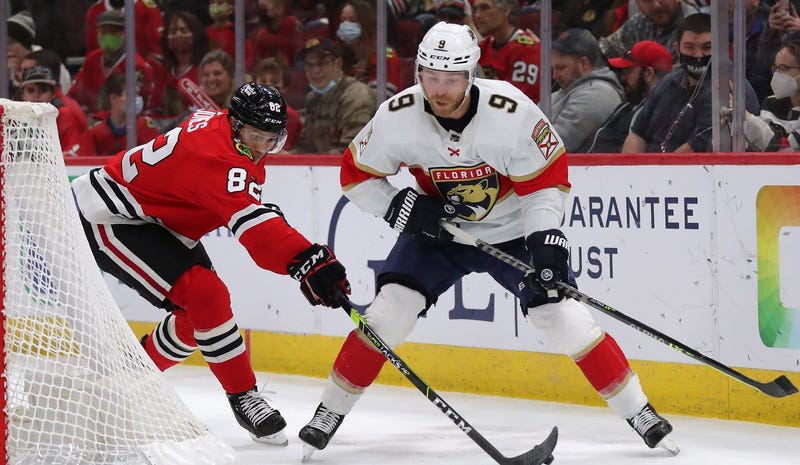 Blackhawks defenseman Caleb Jones (82) stick-checks Panthers center Sam Bennett (9).