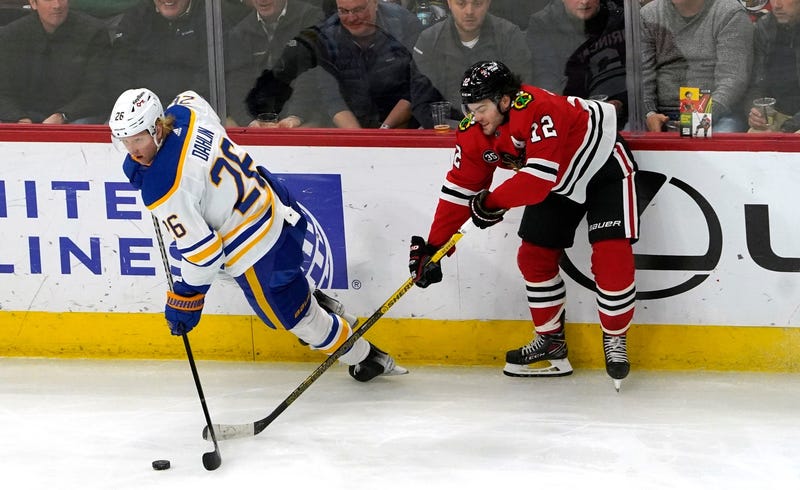 Sabres defenseman Rasmus Dahlin (26) and Blackhawks left wing Alex DeBrincat (12) go for the puck.