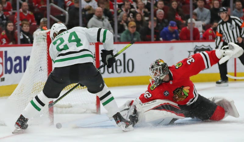 Blackhawks goaltender Kevin Lankinen (32) makes a save on a shot from Stars center Roope Hintz (24).
