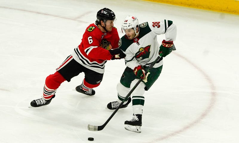 Blackhawks defenseman Jake McCabe (6) defends Wild right wing Ryan Hartman (38)).