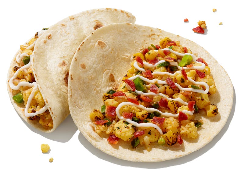 Breakfast tacos from Dunkin'. Open face tacos with crambled eggs, melted sharp white cheddar cheese, fire-roasted corn, and a drizzle of tangy lime crema.