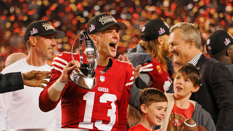San Francisco 49ers quarterback Brock Purdy (13) holds the George Halas Trophy while after winning the NFC Championship football game against the Detroit Lions at Levi's Stadium.