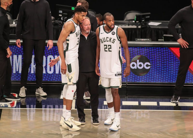 Jun 19, 2021; Brooklyn, New York, USA; Milwaukee Bucks head coach Mike Budenholzer stands with forward Giannis Antetokounmpo (34) and forward Khris Middleton (22) after defeating the Brooklyn Nets in overtime in game seven in the second round of the 2021 NBA Playoffs at Barclays Center. Mandatory Credit: Wendell Cruz-USA TODAY Sports