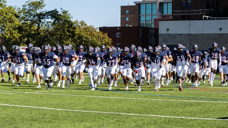Duquesne football runs onto the field