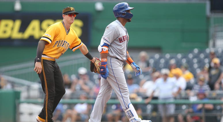   Pirates shortstop Kevin Newman tags out Mets second baseman Robinson Cano after Cano suffered an apparent hamstring injury running the bases during the fourth inning at PNC Park in Pittsburgh. 