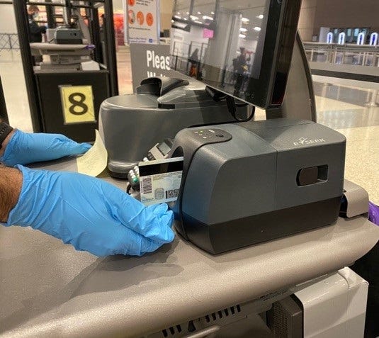 A security screening machine checks a photo ID