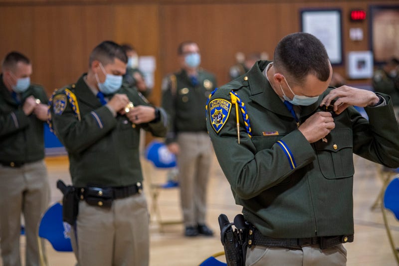 New CHP officers pin on their badges.