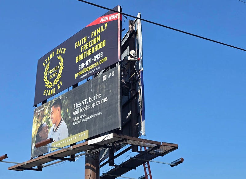 A Lamar Advertising representative on Monday moves an ad for the far-right extremist group Proud Boys; the sign was taken down entirely around noon Tuesday.