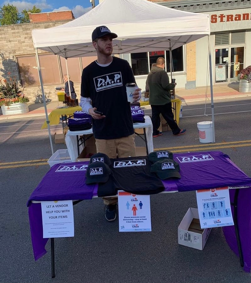 Jay selling D.A.P merchandise