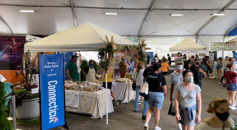 A tent adjacent to the Connecticut building at the Big E fair, promoting various businesses in the state.