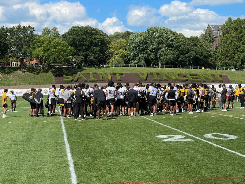 Steelers team with St. Vincent shrubs behind them