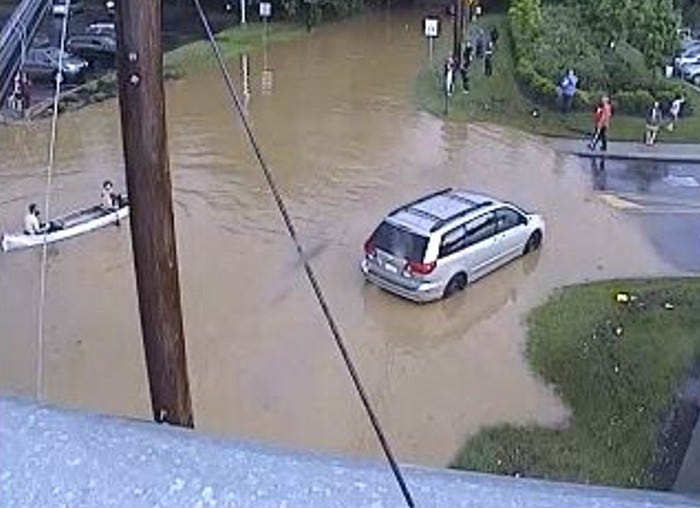 Flooding at Business Route 30 and Route 340, with people getting around by canoe.