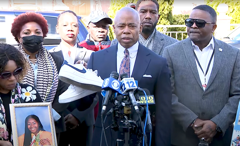 El alcalde Adams sostiene un par de zapatos pertenecientes a Kade Lewin el lunes por la mañana.