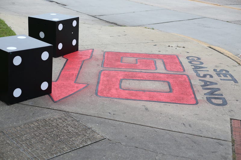 As part of the immersive “game show” experience, the sidewalk leading up to the theater has been painted to look like a Monopoly board.
