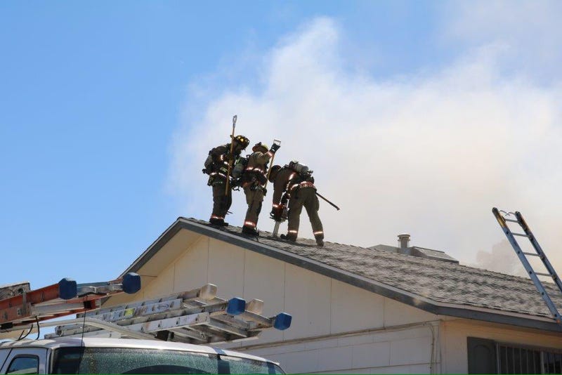 Clark County Fire Department crews work on the roof of a structure fire.