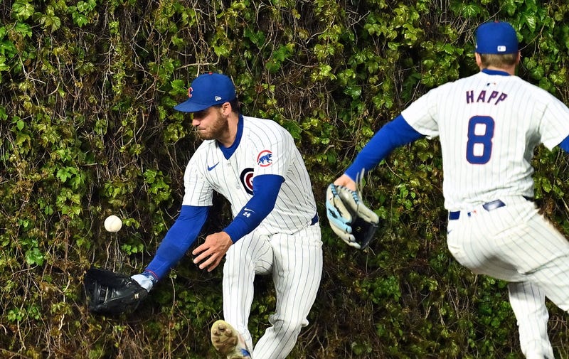 Cubs center fielder Cody Bellinger attempts to catch a ball at the wall at Wrigley Field.