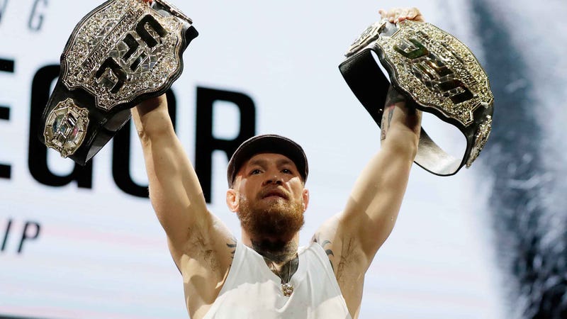 Conor McGregor holds up two UFC belts at a press conference before facing Khabib Nurmagomedov at UFC 229.