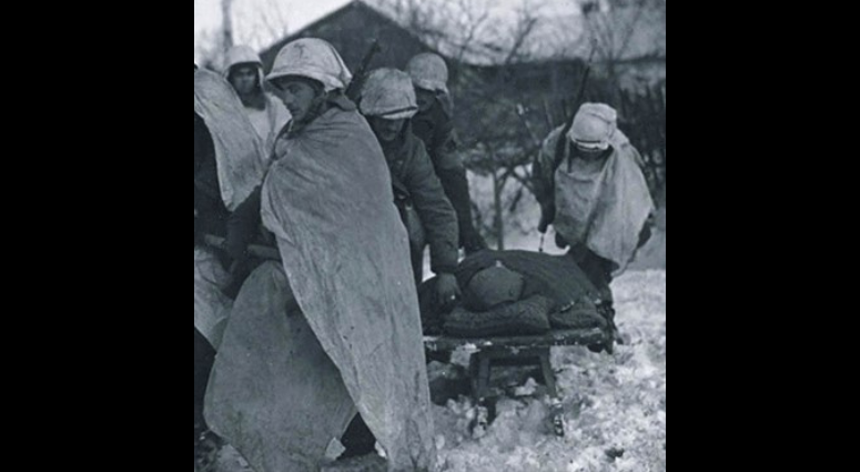 An undated photograph of U.S. Army paratroopers of Company A 509th Parachute Infantry Battalion, 7th Armored Division, pulling a crude sled in the snow to bring in a fellow soldier for medical aid at Born, Belgium, during the Battle of the Bulge from Dec. 16, 1944, to Jan. 25, 1945