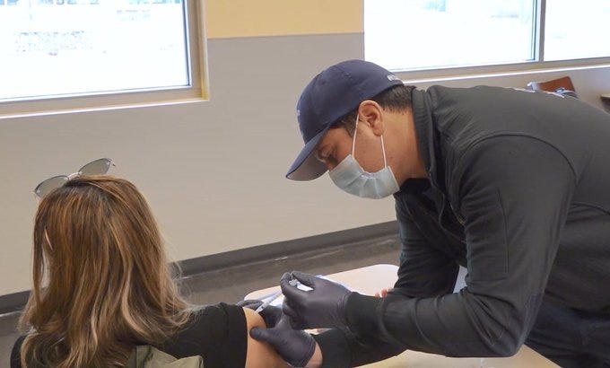 A woman receives her coronavirus vaccination