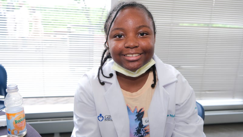 Nahla Muhammad in her doctor's lab coats as part of the Crozer Health ID STEM program Monday at Crozer-Chester Medical Center in nearby Upland.