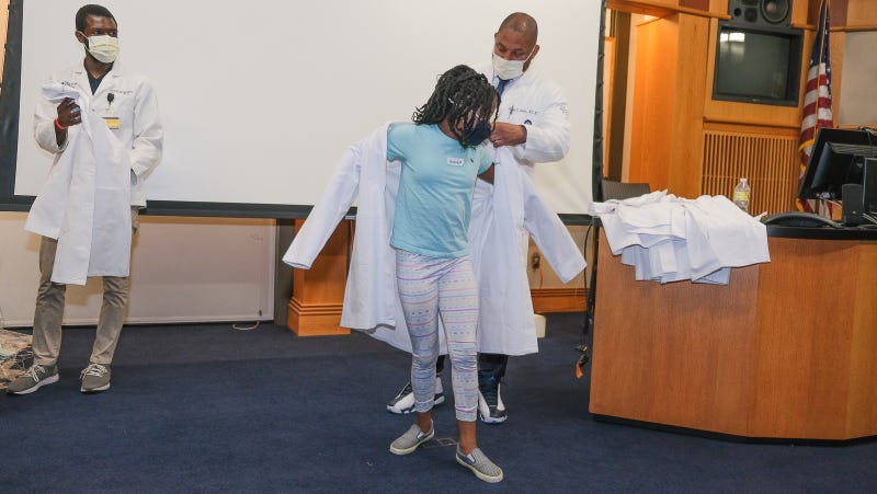 Ionie-Joy Benjamin, part of the Crozer Health ID STEM program, gets her doctor's coat.