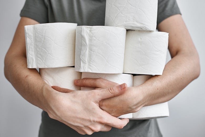 Man holding rolls of toilet paper