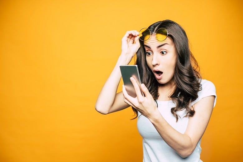 woman reacting to a DM on her phone
